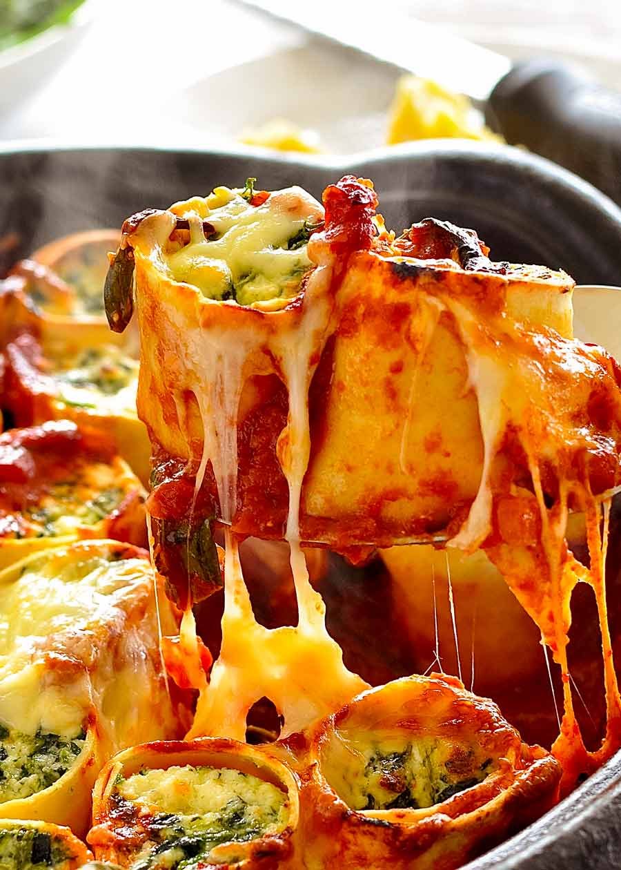Spoon lifting up Spinach and Ricotta Rotolo - cheese pull close up!