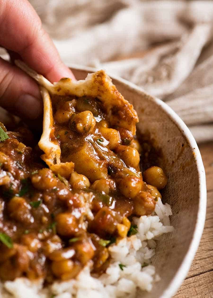 Close up of Chickpea Curry (Chana Aloo) being scooped up with Easy Soft Flatbread
