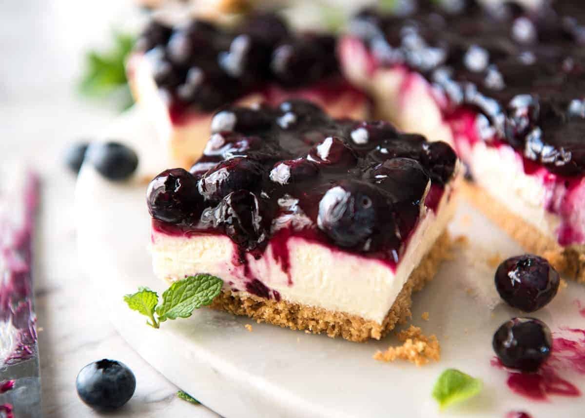 Easy and fast No Bake Blueberry Cheesecake Bars - creamy cheesecake with a gorgeous fresh blueberry sauce topping! staging.recipetineats.com