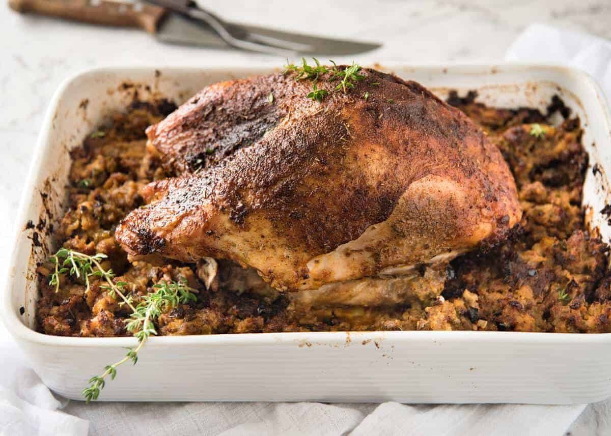 This Cajun dry brined turkey breast is baked in the same roasting pan as the Dressing / Stuffing so it's extra juicy and moist! A chef recipe, this Cajun Baked Turkey Breast with Dressing is easy and spectacular. EPIC ONE PAN COOKING for a Thanksgiving turkey! staging.recipetineats.com
