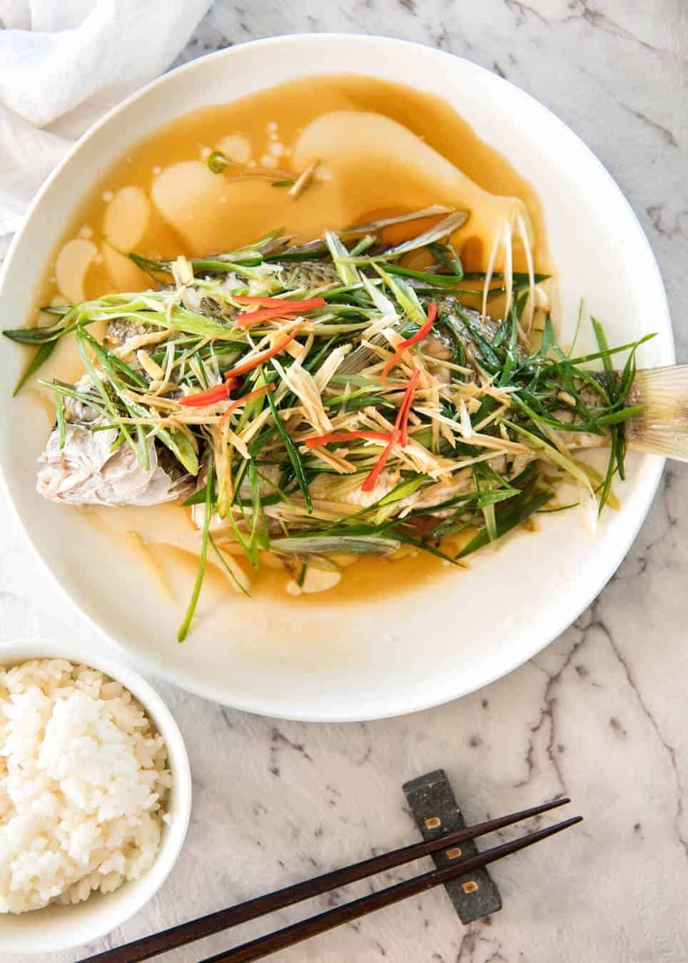 A Chinese Steamed Fish topped with Ginger and Shallots and seasonings, with hot oil poured over it to create a dramatic sizzle and an amazing sauce. So simple, yet so utterly delicious. Steam OR bake the fish! staging.recipetineats.com