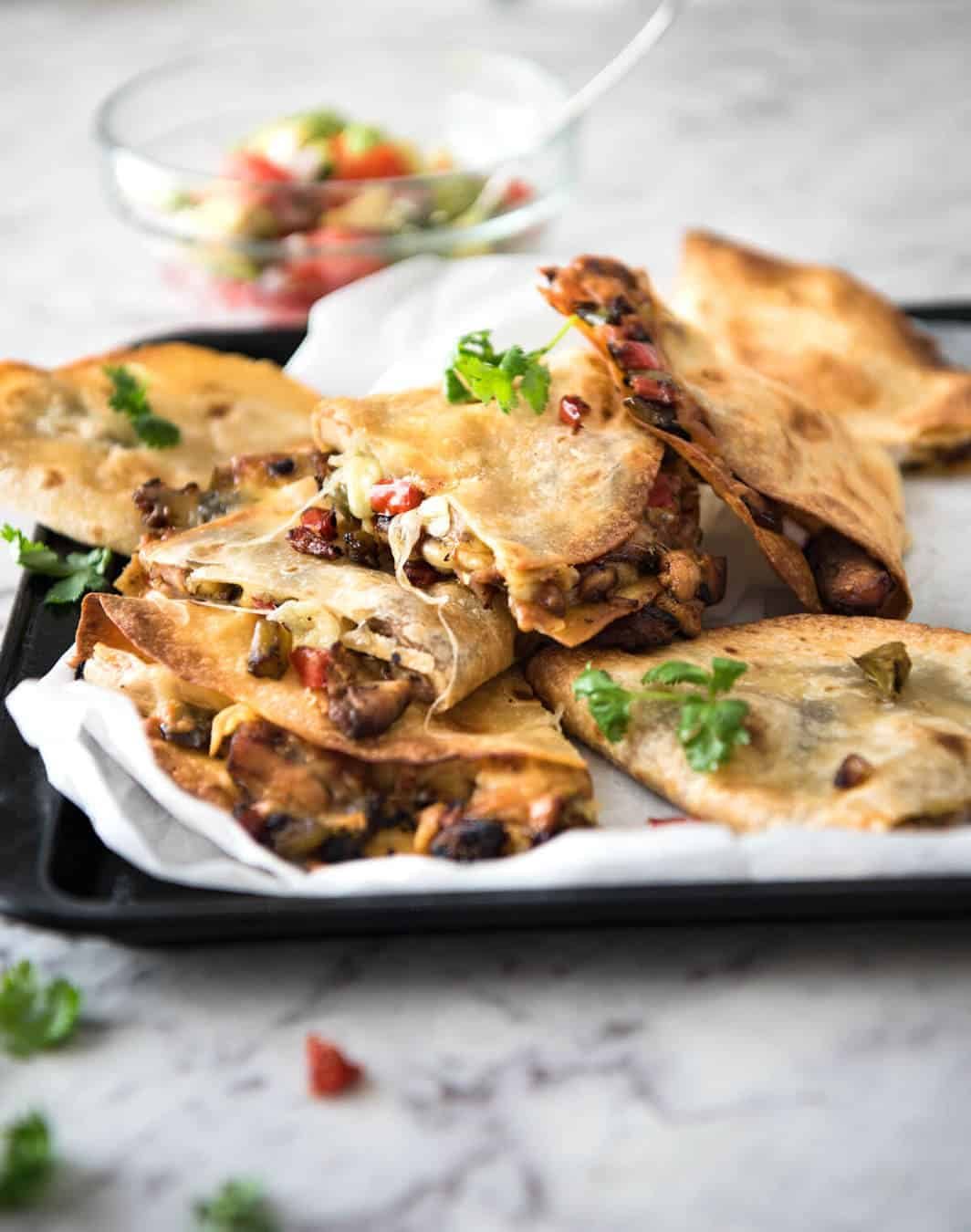 Crispy Oven Baked Chicken Quesadillas - This is how to make multiple Quesadillas at the same time! Crispy on the outside, stuffed with Mexican seasoned chicken and capsicum / bell peppers (and cheese of course!) staging.recipetineats.com