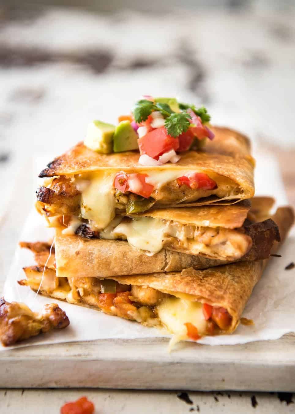 Crispy Oven Baked Chicken Quesadillas - This is how to make multiple Quesadillas at the same time! Crispy on the outside, stuffed with Mexican seasoned chicken and capsicum / bell peppers (and cheese of course!) staging.recipetineats.com