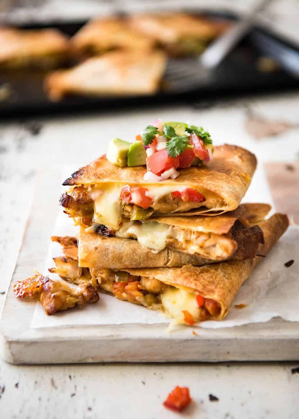 Crispy Oven Baked Chicken Quesadillas - This is how to make multiple Quesadillas at the same time! Crispy on the outside, stuffed with Mexican seasoned chicken and capsicum / bell peppers (and cheese of course!) staging.recipetineats.com