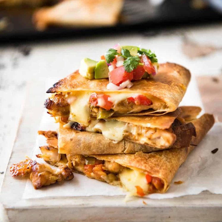 Crispy Oven Baked Chicken Quesadillas - This is how to make multiple Quesadillas at the same time! Crispy on the outside, stuffed with Mexican seasoned chicken and capsicum / bell peppers (and cheese of course!) staging.recipetineats.com