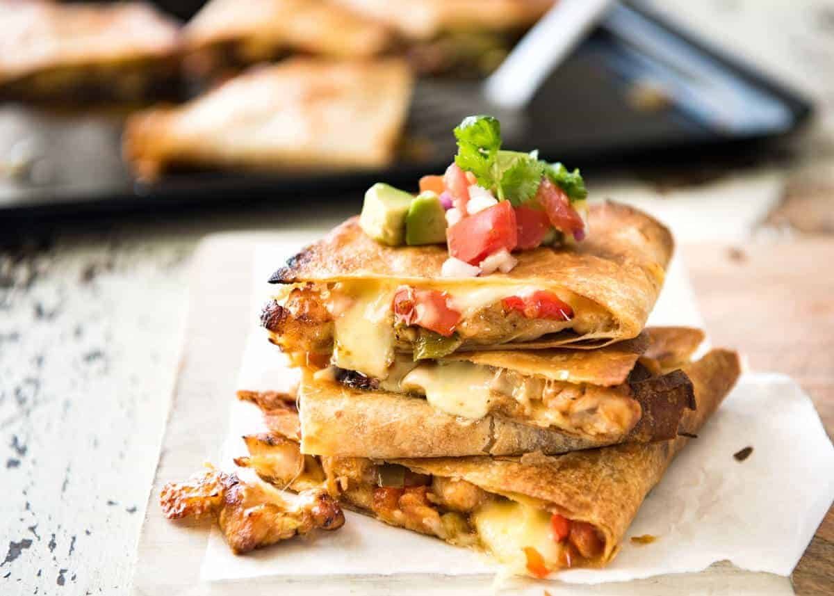 Crispy Oven Baked Chicken Quesadillas - This is how to make multiple Quesadillas at the same time! Crispy on the outside, stuffed with Mexican seasoned chicken and capsicum / bell peppers (and cheese of course!) staging.recipetineats.com