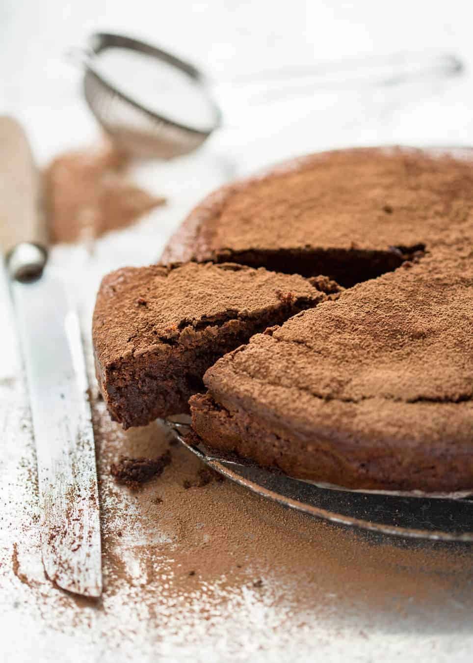 A simple Flourless Chocolate Cake made with almond meal / almond flour. Moist inside, with a thin crackly brownie-like surface. A stunning, very quick cake to make! staging.recipetineats.com