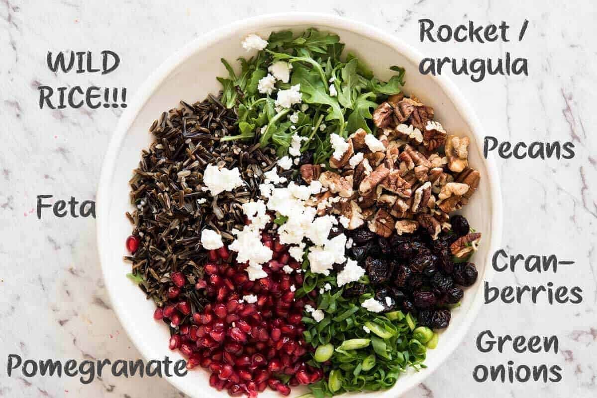 This Wild Rice Salad is a salad for celebrations! Stellar flavour combination - wild rice, pomegranate, pecans, rocket / arugula, green onions, cranberries and feta. staging.recipetineats.com