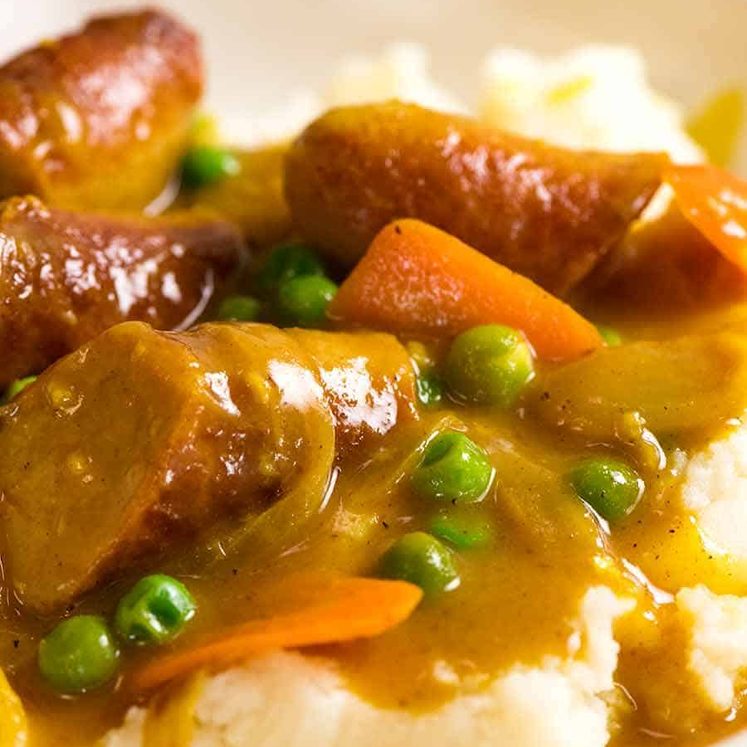 Curried Sausages over mash in a bowl, ready to be eaten