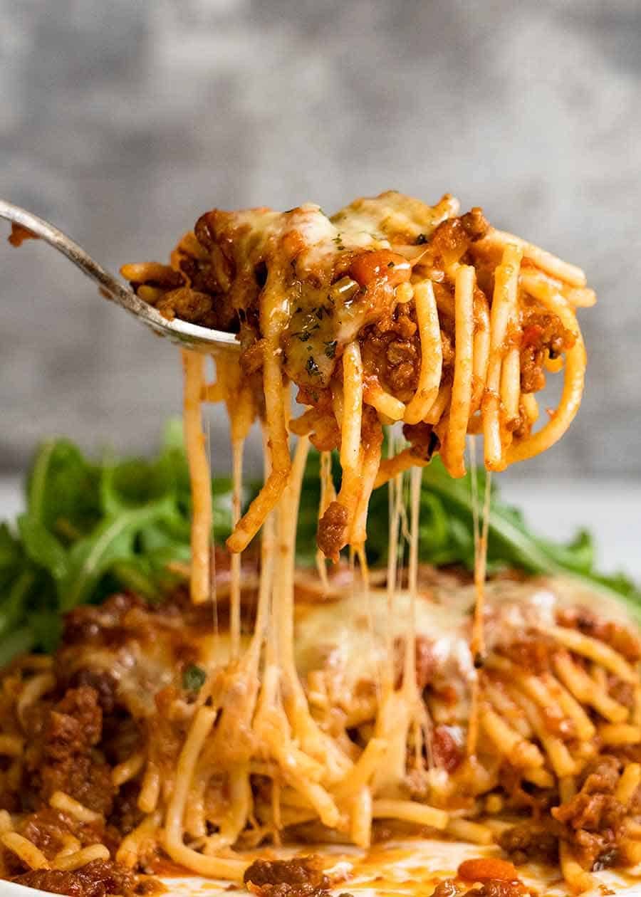 Forking lifting up cheesy Baked Spaghetti