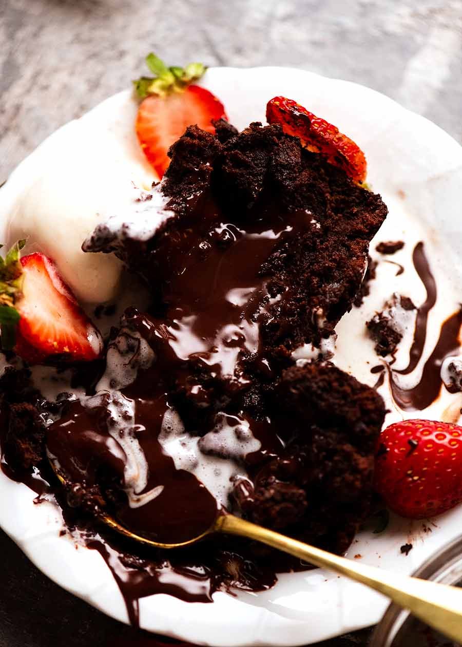 Plate with Molten Chocolate Cake with chocolate lava pouring out being eaten with ice cream
