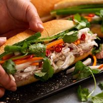Hand picking up Chicken banh mi